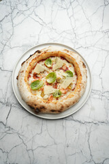 Pizza with shrimp, cheese and herbs on a white plate