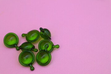 Hair vitamin capsules for hair care, isolated on pink background with close up view.