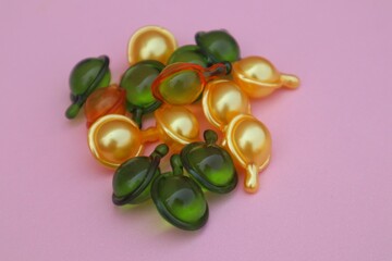 Hair vitamin capsules for hair care, isolated on pink background with close up view.