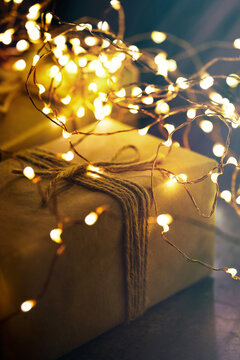 Wrapped Christmas gift with glowing fairy lights