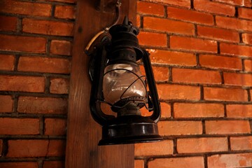 An old lantern using kerosene as fuel, hanging on the wall of the house. With a close look.