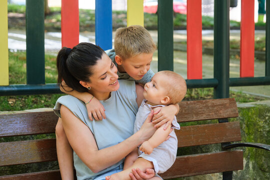 Tender moment with mom embracing her two young children