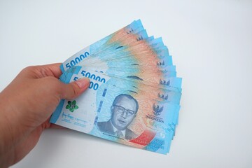 Woman holding several bills worth Rp. 50000, isolate on white background.