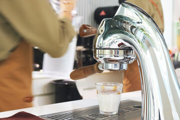 Single head espresso machine with coffee measuring cup.