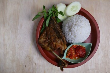 Penyet ayam or fried chicken in Indonesia is the name of a typical Javanese food consisting of fried chicken and chili sauce.