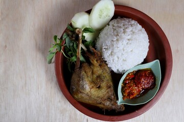 Penyet ayam or fried chicken in Indonesia is the name of a typical Javanese food consisting of fried chicken and chili sauce.