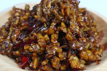 Stir-fried Tempe is a typical Indonesian dish with spices, garlic, shallots, chilies and soy sauce. served on a wooden plate