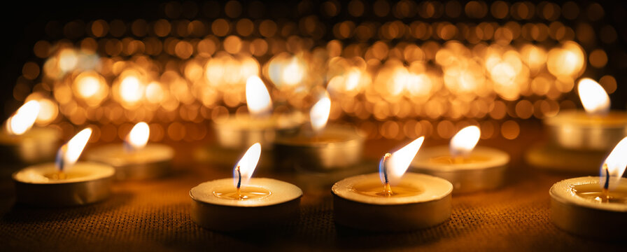 All Saints' Day panoramic banner with bokeh effect. Solemnity of All Saints. All Hallows' Day. Candles with fire on shiny background - Powered by Adobe