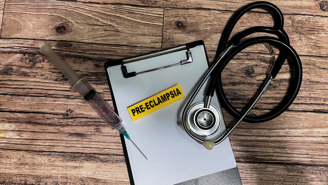 Concept of Pre-Eclampsia write on sticky notes isolated on Wooden Table.