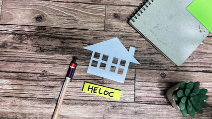Concept of Heloc write on sticky notes isolated on Wooden Table.