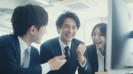 モニターを見て成功を喜ぶビジネスチーム