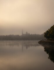 Misty morning lake with reflections and walkers