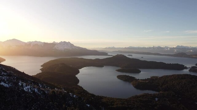 Drone scenery of Nahuel Huapi Lake with cliffs at sunset in San Carlos de Bariloche, Argentina