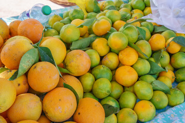 Fresh mandarin oranges or tangerines with leaves on market stall, background,