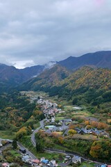 Aerial view of a town in a lush green valley with mountains.