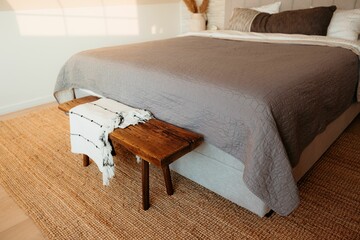 Cozy bedroom with wooden bench and woven rug