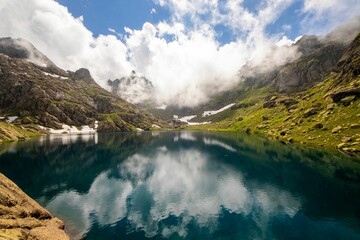 Mountain landscape with a reflective lake and blue sky.