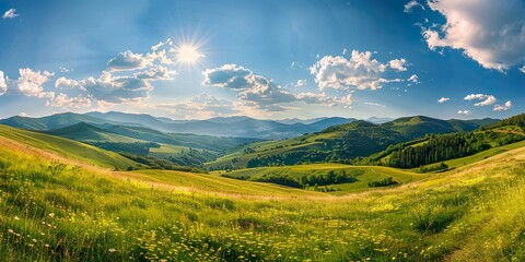 A beautiful summer landscape featuring green fields and majestic mountains under a blue sky, with fluffy clouds scattered above a peaceful valley