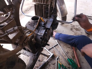 Close-up of mechanic repairing motorcycle.