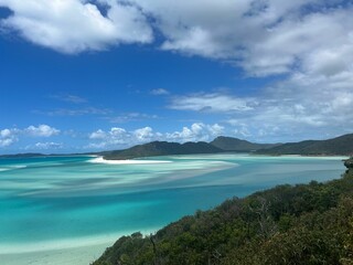 view of turquoise waters surrounded by green cliffs in Coral Sea Marina beach in Australia