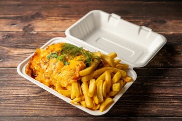 Takeout meal with cheesy lasagna and fries.