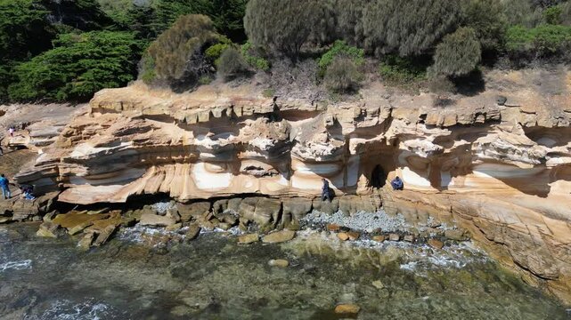 Pull-back aerial footage of the scenic Painted Cliffs on Maria Island, Tasmania, Australia