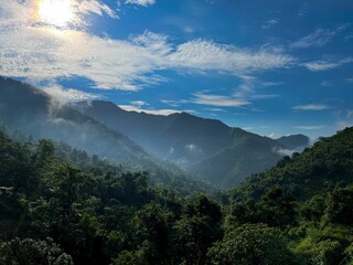 Scenic view of green mountains under a bright blue sky.