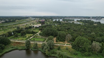 Fototapeta premium Aerial view of a green park with a lake and colorful building.