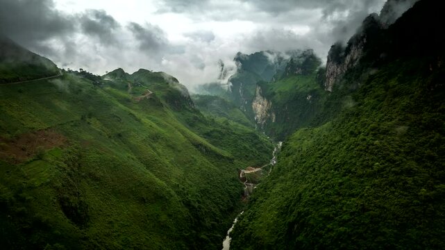 Drone hyperlpase of scenic valley with eerie swirling mountain fog around peaks