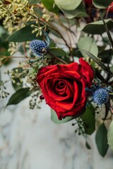 Red rose in green and blue bouquet