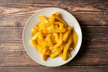Cheesy fries on wooden table