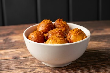 Bowl of fried dough balls with brown sugar topping