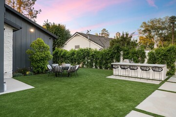 Modern backyard with dining set and bar area at sunset