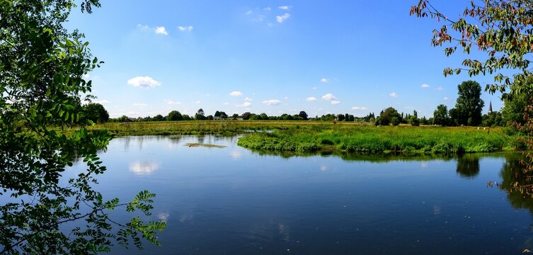 Nature photo of the river, The Niers with a beautiful reflection of the blue sky and white clouds