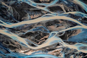 Aerial view of braided river patterns in a glacial landscape.