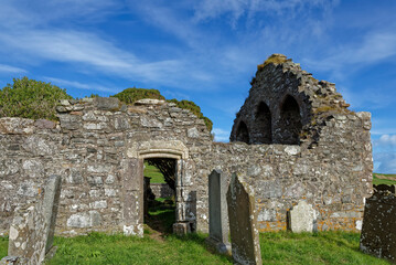 The side entrance and East Gable of St Mary and St Nathalan Chapel ruins, with Tombstones in the foreground of the Kirkyard.