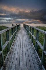 Naklejka premium Boardwalk to the ocean at sunset
