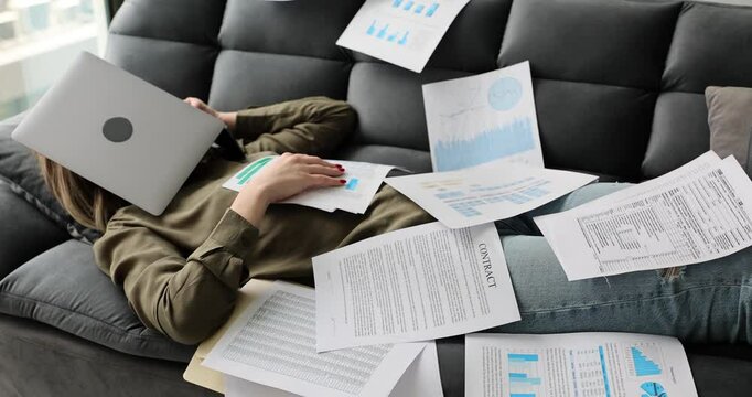Overworked freelancer and online work at home. Exhausted tired female manager falling asleep by with laptop paper charts