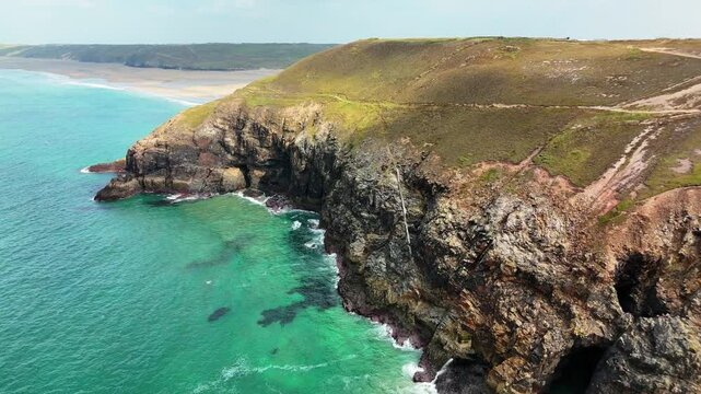 Aerial footage of sea and cliffs on a sunny day at St Agnes Heritage Coast in Cornwall, England