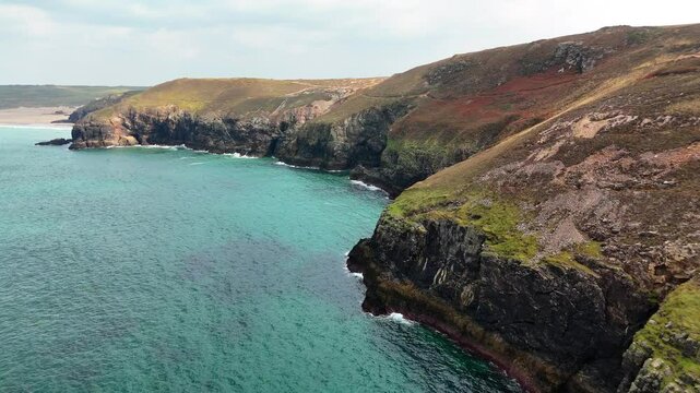 Aerial view of seafront cliffs on a sunny day at St Agnes Heritage Coast in Cornwall, Perranporth