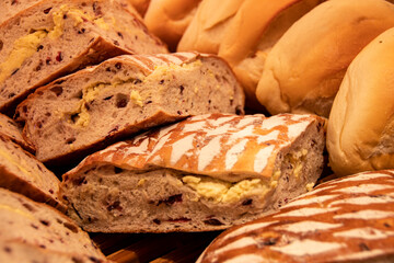 Closeup of a variety of breads and pastries displayed on a bakery shelf