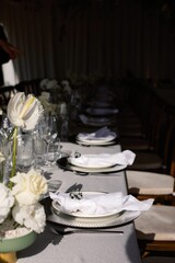 Elegant table setting with white flowers and napkins.