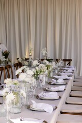 Elegant floral arrangements with white flowers in vases on a table in a wedding venue