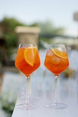Closeup of two glasses filled with Aperol Spritz cocktails