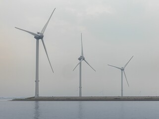 Wind turbines on a coastal area with a calm sea