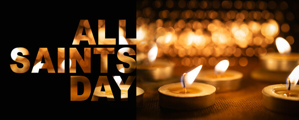 All Saints' Day panoramic banner with bokeh effect. Solemnity of All Saints. All Hallows' Day. Candles with fire on shiny background with text on black