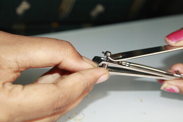 close-up of a girl trimming her nails using nail cutter.