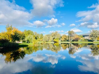autumn trees reflection on the lake surface, blue lake reflection, golden autumn, lake in the park with quiet water as a mirror 