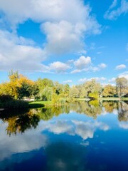 autumn trees reflection on the lake surface, blue lake reflection, golden autumn, lake in the park with quiet water as a mirror 