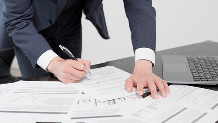 急いで資料を確認するビジネスマンの手元